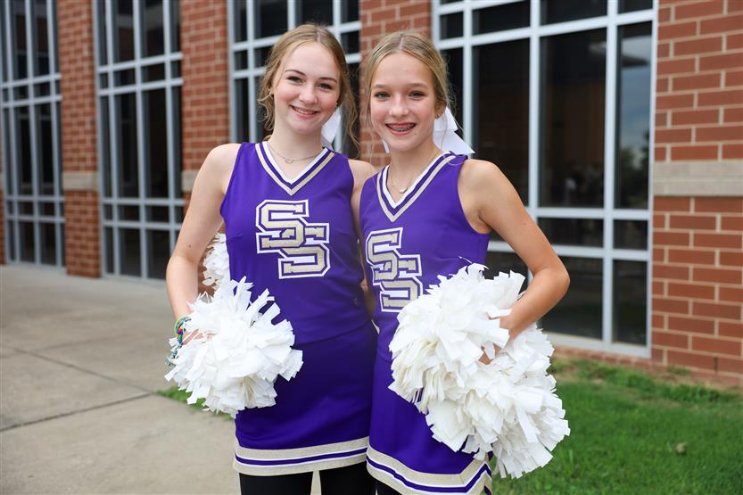 Two cheerleaders smile
